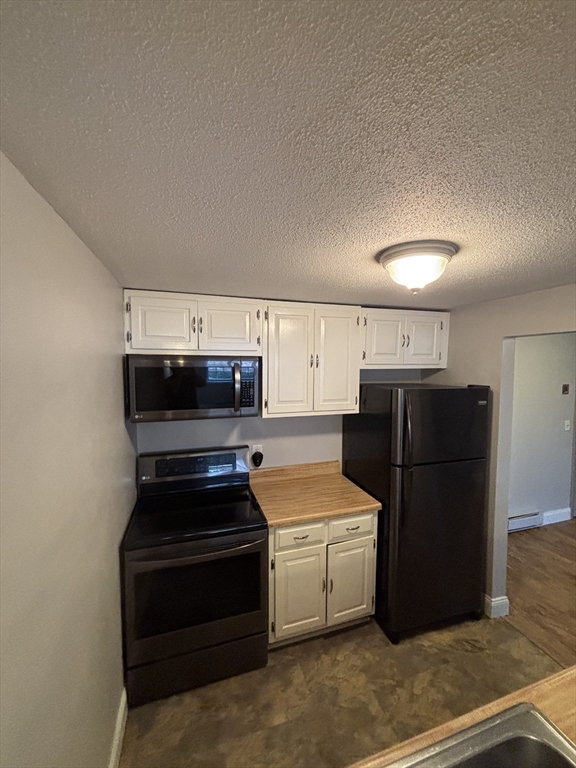 43 Berlin Street, Unit 411 Clinton, MA 01510 - Photo 4 of 14 a kitchen with a refrigerator and a stove top oven