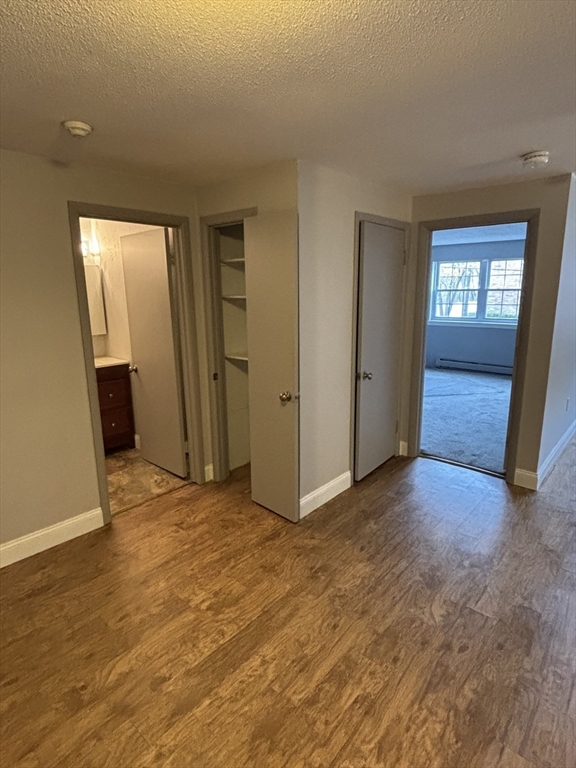 43 Berlin Street, Unit 411 Clinton, MA 01510 - Photo 8 of 14 a view of an empty room with window and wooden floor