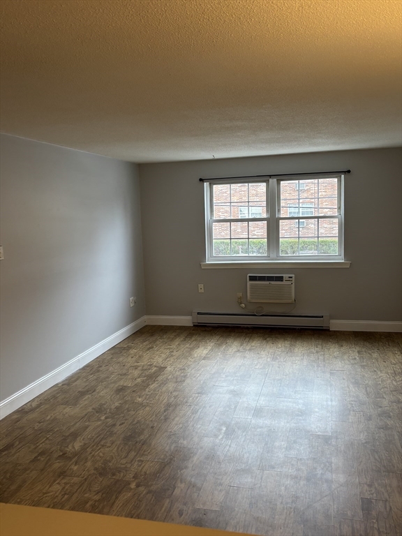 43 Berlin Street, Unit 411 Clinton, MA 01510 - Photo 9 of 14 an empty room with wooden floor and windows