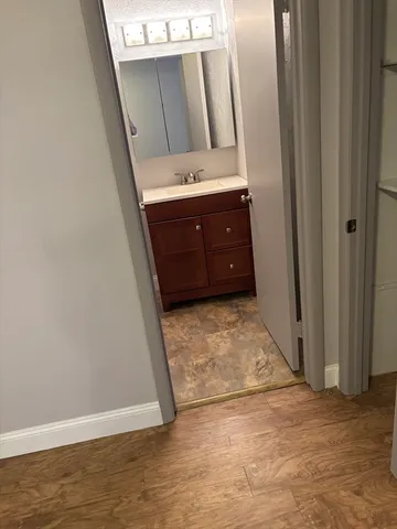 a view of a refrigerator in kitchen and an empty room