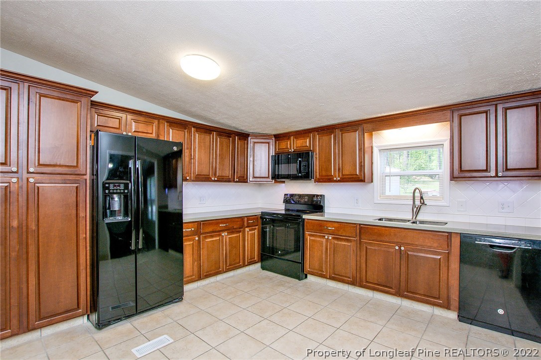 246 Loop Road Raeford, NC 28376 - Photo 18 of 42 a kitchen with stainless steel appliances granite countertop a refrigerator and sink
