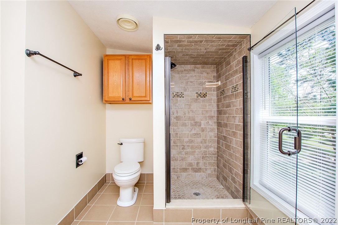 246 Loop Road Raeford, NC 28376 - Photo 33 of 42 a bathroom with a granite countertop toilet a mirror and shower