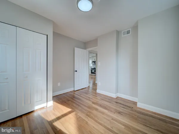 a view of empty room with wooden floor