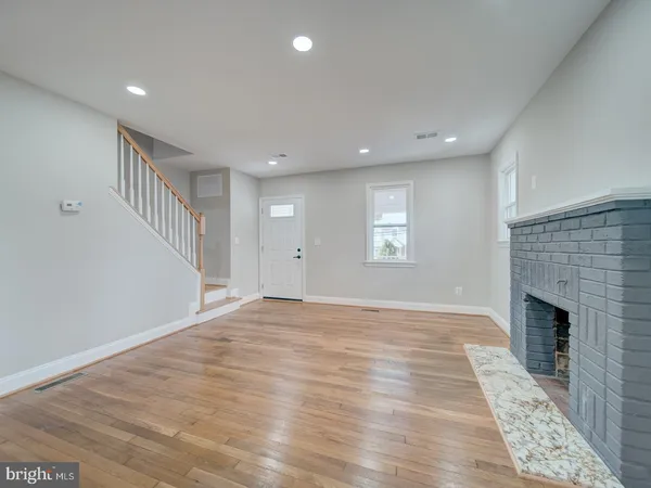 an empty room with windows and fireplace