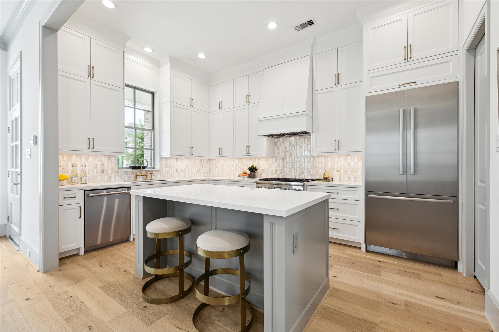207 Sutton Row Place Houston, TX 77024 - Photo 4 of 29 Kitchen features Thermador stainless steel appliances and Bosch refrigerator, Calacatta Gold Quartz countertops and Marble mosaic backsplash.