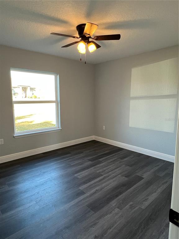55 Northwest 45th Loop Ocala, FL 34475 - Photo 13 of 20 an empty room with wooden floor fan and windows