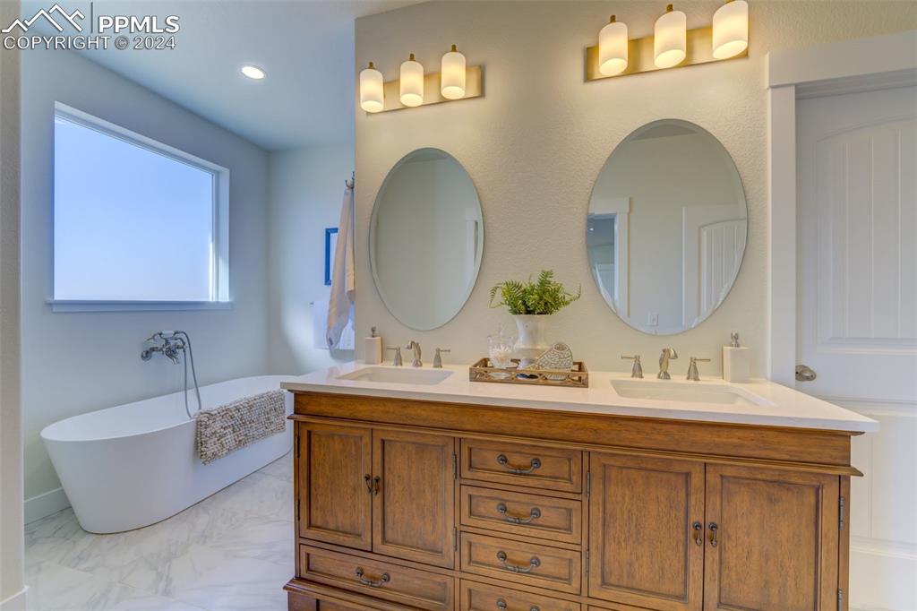 430 Miners Road Canon City, CO 81212 - Photo 20 of 50 a bathroom with a double vanity sink a mirror and bathtub