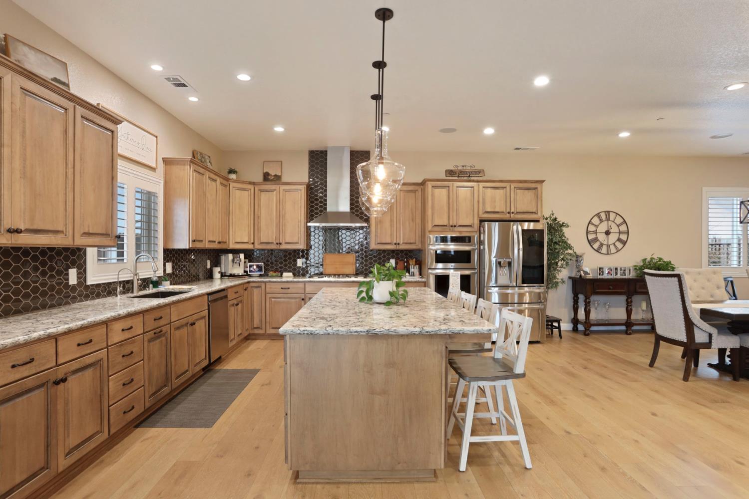 23346 Frederick Road Ripon, CA 95366 - Photo 22 of 96 a large kitchen with stainless steel appliances kitchen island granite countertop a large island in the center