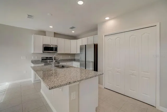 a kitchen with stainless steel appliances a refrigerator and microwave