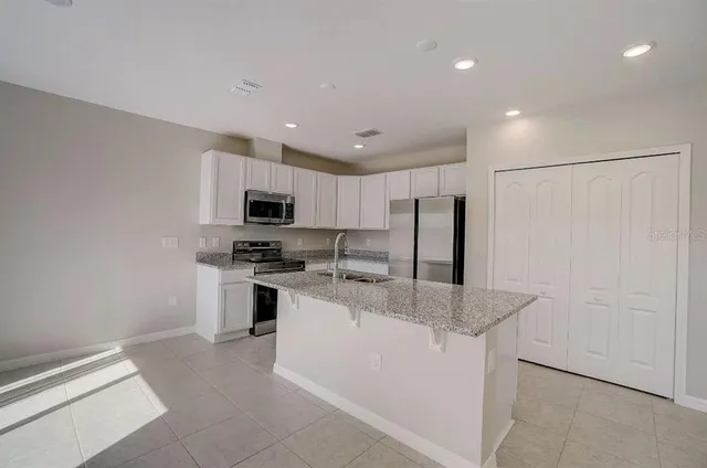 a kitchen with stainless steel appliances granite countertop a stove a sink and a refrigerator