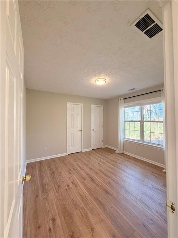 2575 Hamilton Parc Lane Northeast Buford, GA 30519 - Photo 20 of 63 an empty room with wooden floor and windows
