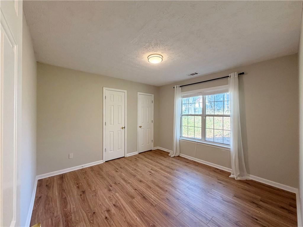 2575 Hamilton Parc Lane Northeast Buford, GA 30519 - Photo 21 of 63 an empty room with wooden floor and windows