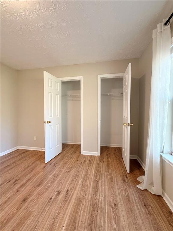 2575 Hamilton Parc Lane Northeast Buford, GA 30519 - Photo 23 of 63 an empty room with wooden floor and entrance
