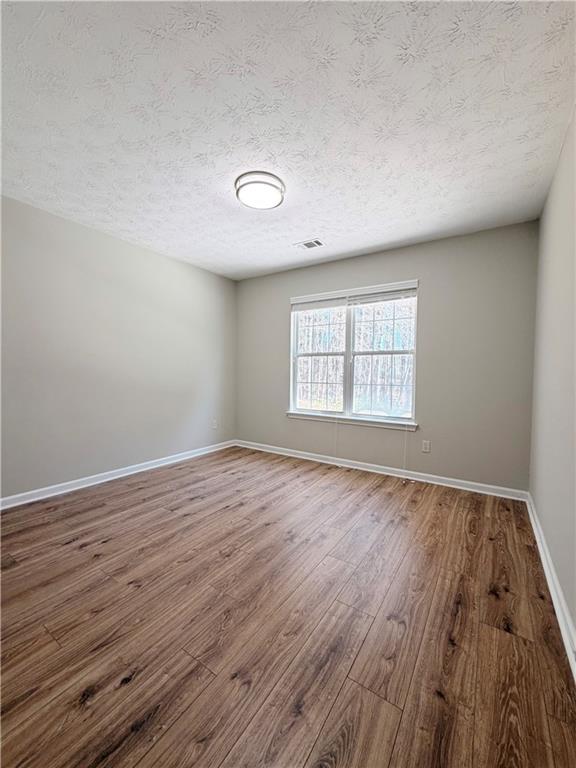 2575 Hamilton Parc Lane Northeast Buford, GA 30519 - Photo 25 of 63 an empty room with wooden floor and windows