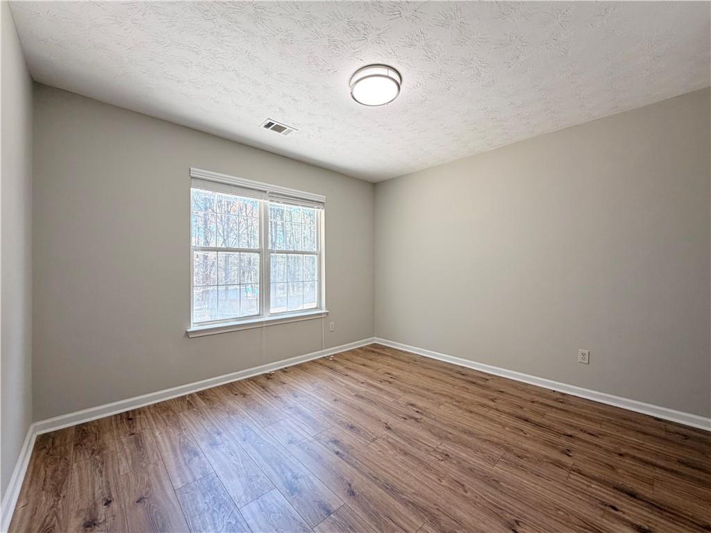 2575 Hamilton Parc Lane Northeast Buford, GA 30519 - Photo 27 of 63 an empty room with wooden floor and windows