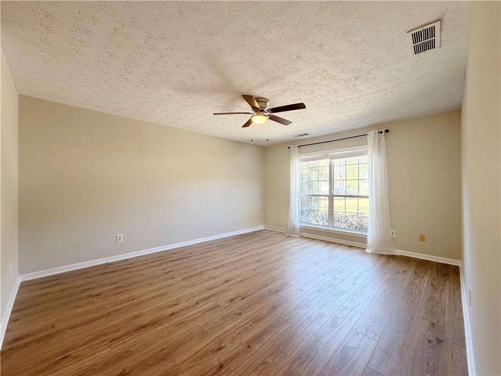 2575 Hamilton Parc Lane Northeast Buford, GA 30519 - Photo 41 of 63 a view of an empty room with wooden floor and a window