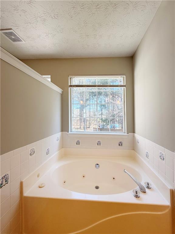 2575 Hamilton Parc Lane Northeast Buford, GA 30519 - Photo 48 of 63 a bathroom with a bathtub and next to a window