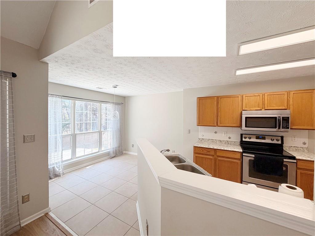 2575 Hamilton Parc Lane Northeast Buford, GA 30519 - Photo 60 of 63 a kitchen with stainless steel appliances a stove sink and cabinets