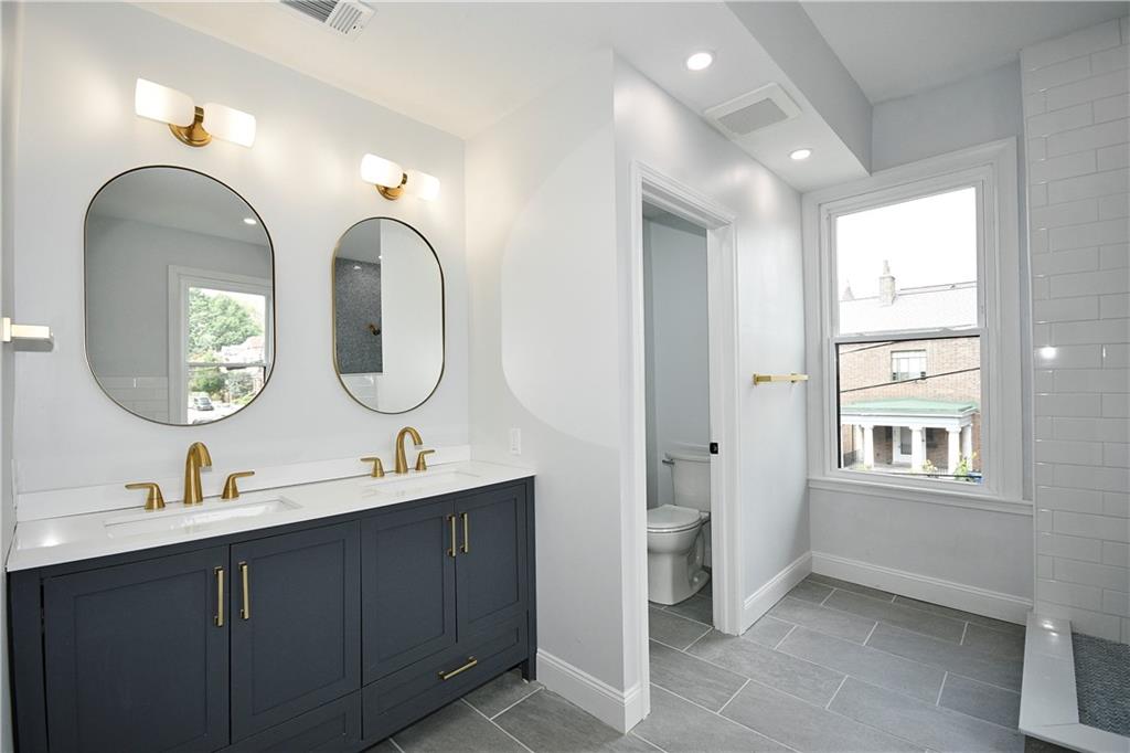 6029 Stanton Avenue Pittsburgh, PA 15206 - Photo 15 of 27 a bathroom with 2 sink and a mirror