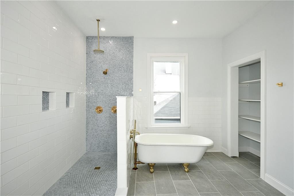 6029 Stanton Avenue Pittsburgh, PA 15206 - Photo 16 of 27 a bathroom with a glass shower door and a toilet