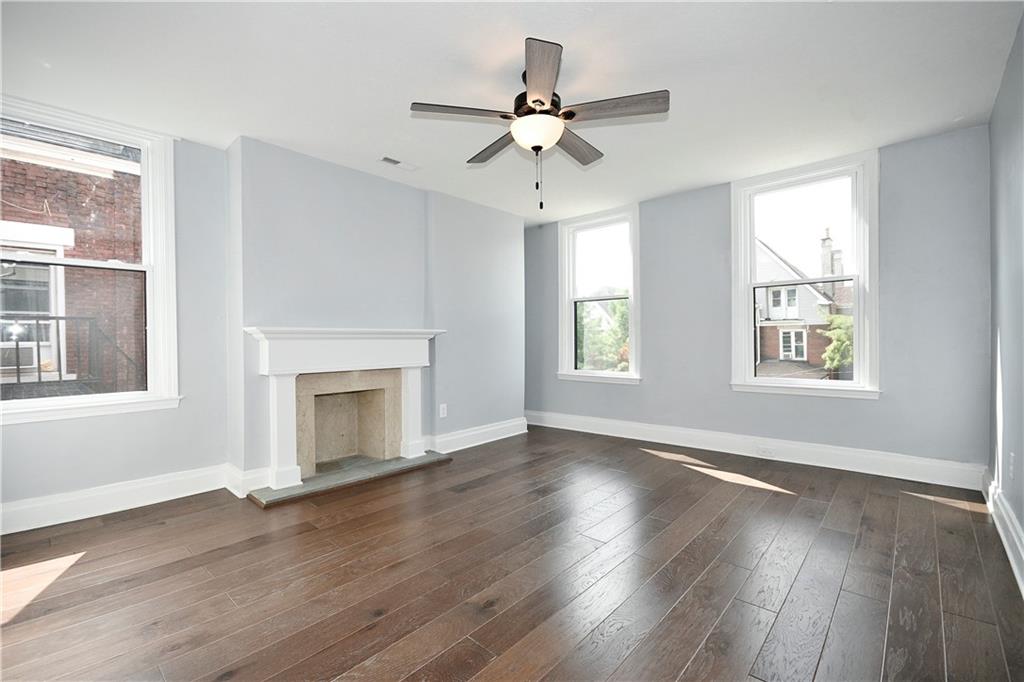 6029 Stanton Avenue Pittsburgh, PA 15206 - Photo 17 of 27 an empty room with wooden floor fan and windows