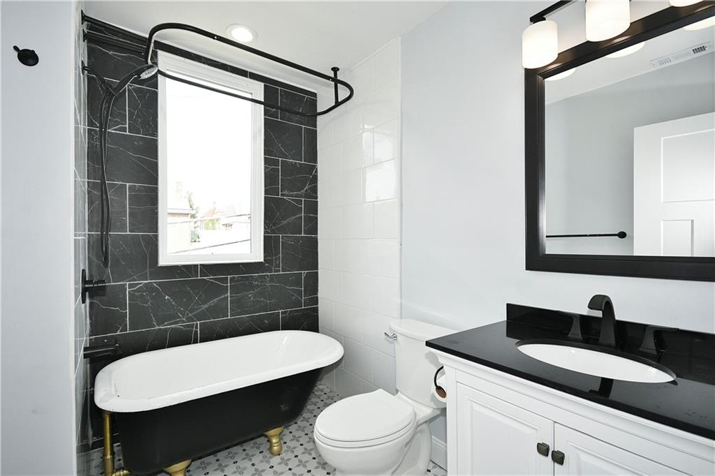 6029 Stanton Avenue Pittsburgh, PA 15206 - Photo 19 of 27 a bathroom with a toilet a sink and a mirror