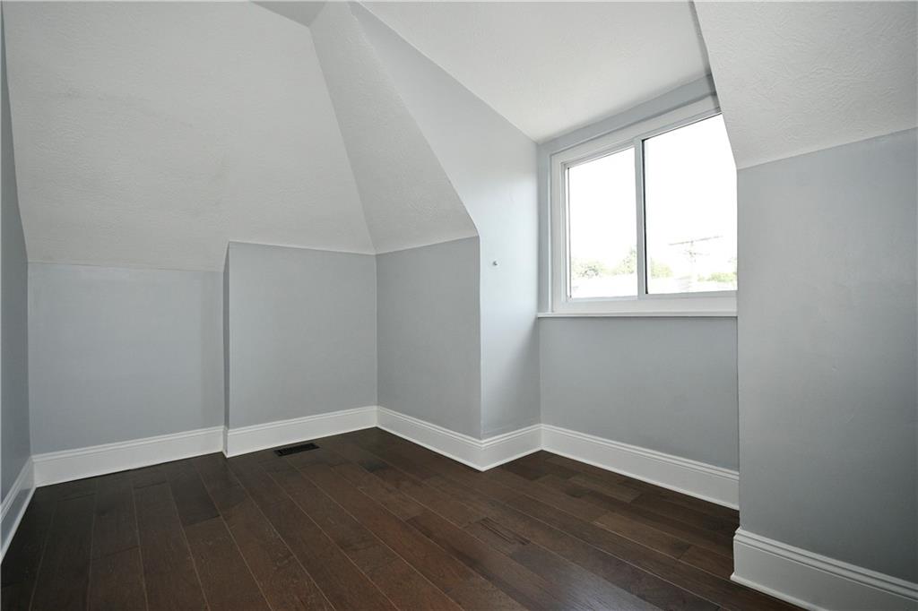 6029 Stanton Avenue Pittsburgh, PA 15206 - Photo 23 of 27 an empty room with wooden floor and windows