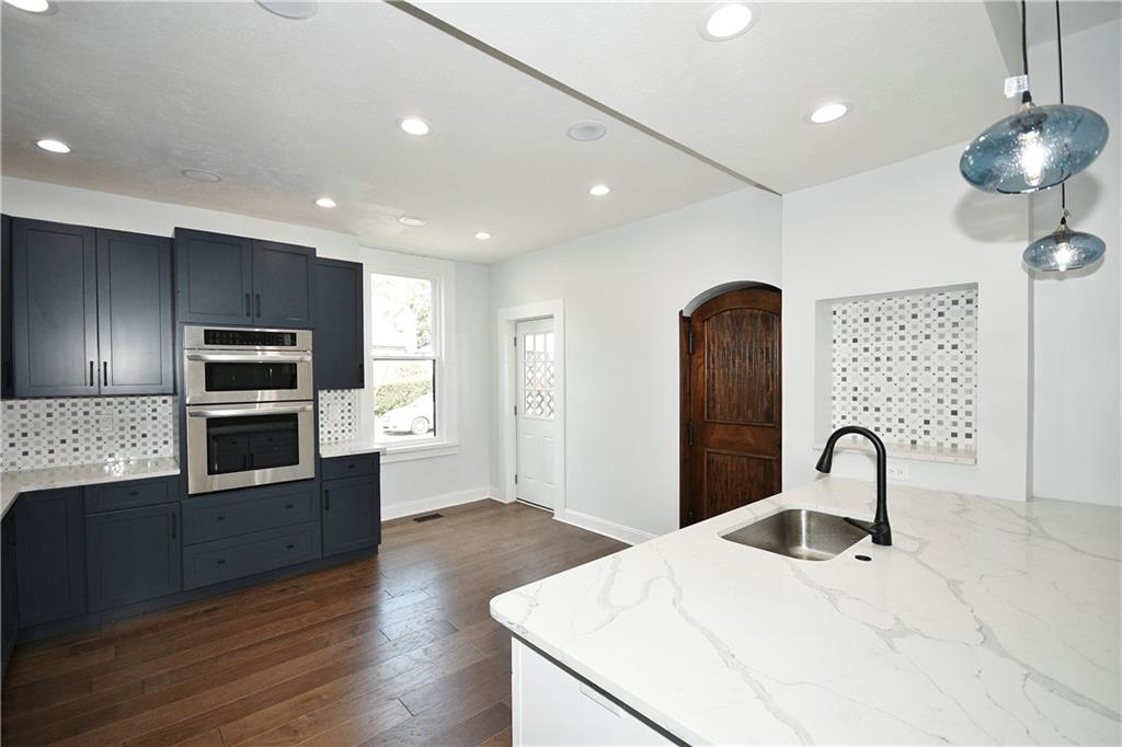 6029 Stanton Avenue Pittsburgh, PA 15206 - Photo 9 of 27 a kitchen with stainless steel appliances granite countertop a sink a microwave and wooden floor