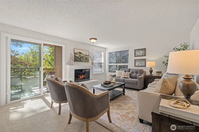a living room with furniture a large window and a fireplace