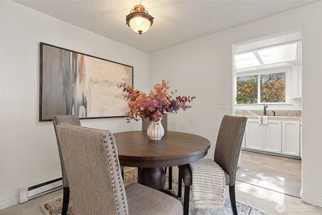 a kitchen with stainless steel appliances a stove a sink a dining table and chairs