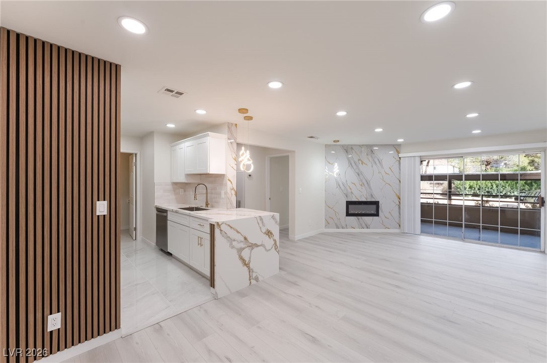 2200 South Fort Apache Road, Unit 1101 Las Vegas, NV 89117 - Photo 8 of 42 Unfurnished living room with recessed lighting, a premium fireplace, and an accent wall