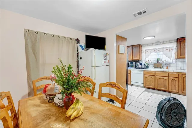 a kitchen with stainless steel appliances kitchen island granite countertop a refrigerator a stove a sink dishwasher and white cabinets with wooden floor
