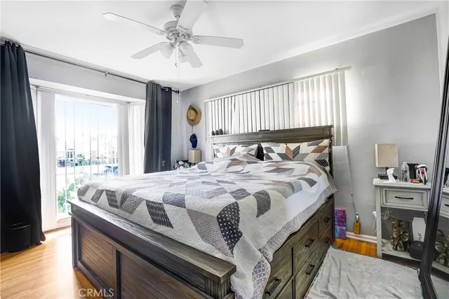 a bed sitting in a bedroom next to a window with a chandelier and dresser