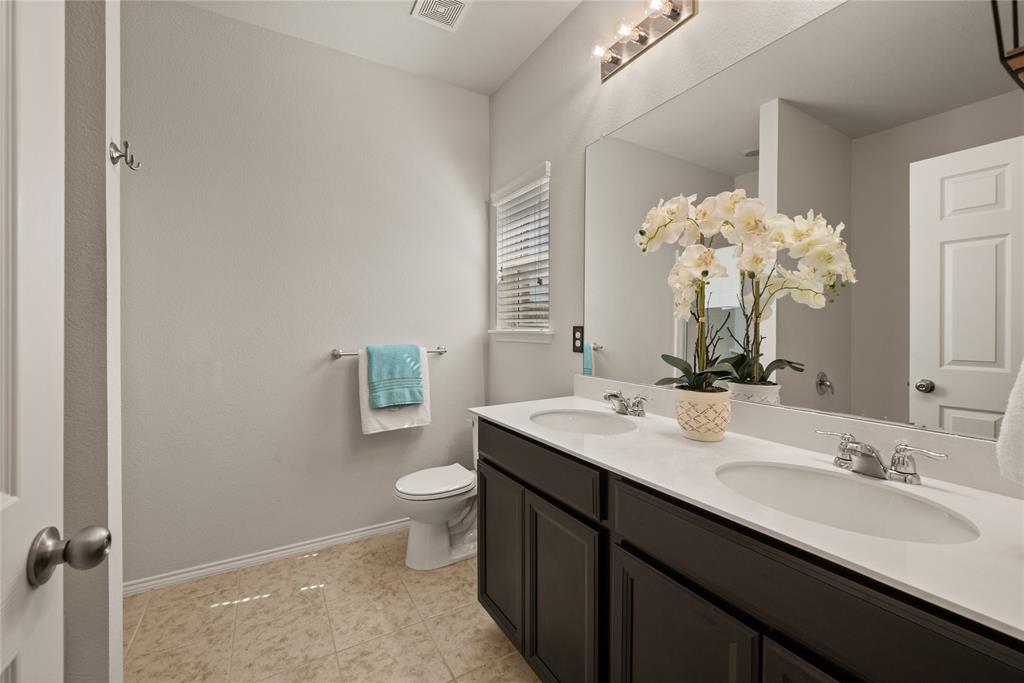 537 Running Water Trail Fort Worth, TX 76131 - Photo 18 of 31 a bathroom with a double vanity sink toilet and a mirror