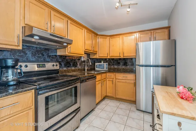 a kitchen with stainless steel appliances granite countertop a refrigerator sink and cabinets