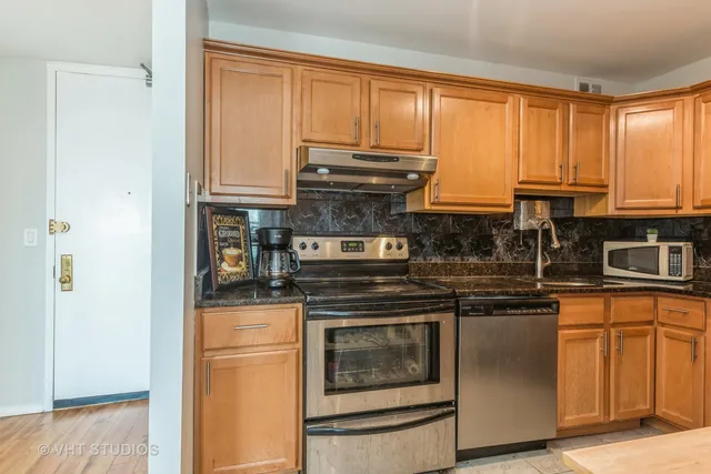 a kitchen with stainless steel appliances granite countertop a refrigerator and a sink