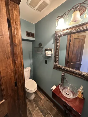a bathroom with a toilet a sink and mirror