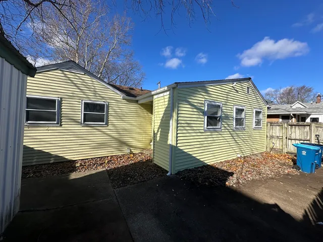 a view of a house with backyard and wooden fence