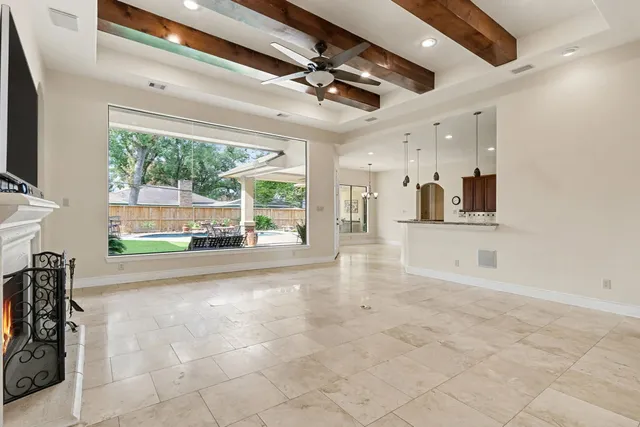 a view of a livingroom with a fireplace a ceiling fan and window