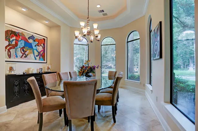 a view of a dining room with furniture a chandelier and window