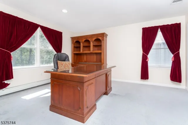 a view of an empty room with wooden floor and windows