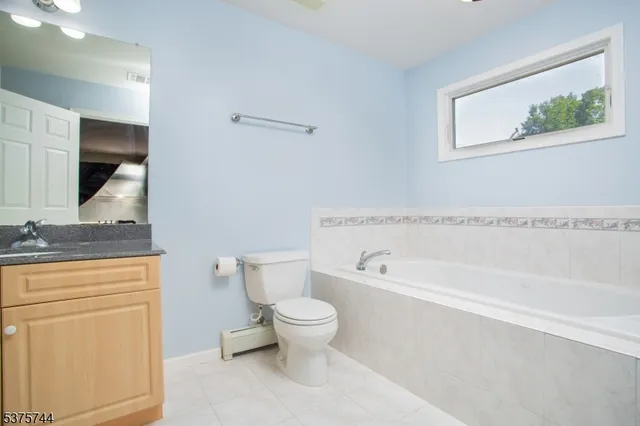 a bathroom with a granite countertop toilet a sink and bathtub