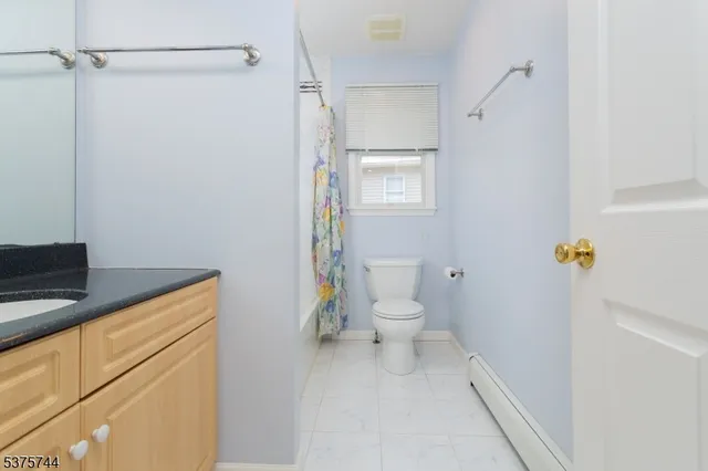 a bathroom with a granite countertop toilet and a sink