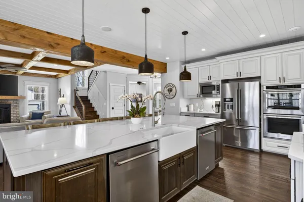 a kitchen that has a sink a stove and wooden cabinets