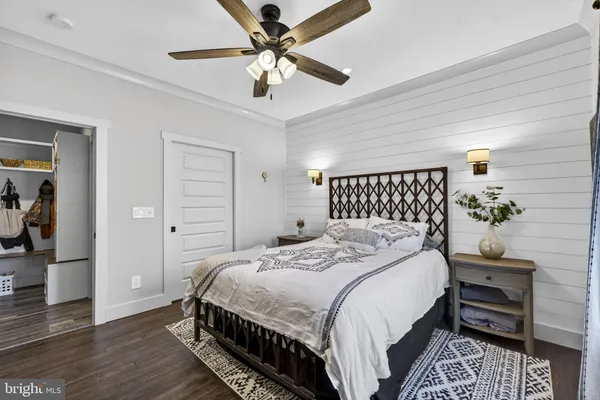 a spacious bedroom with a bed and wooden floor