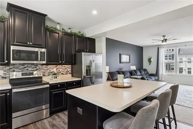 a kitchen with stainless steel appliances a dining table and chairs