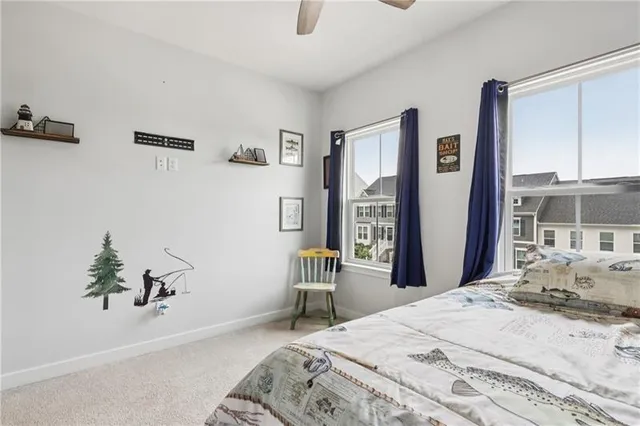 a bedroom with a bed wooden floor and a large window