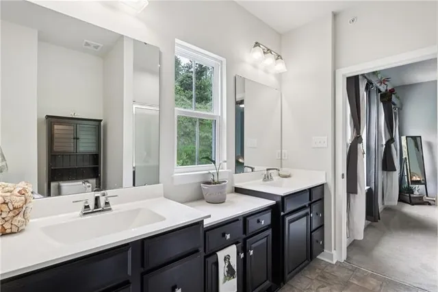a bathroom with double sink and a mirror
