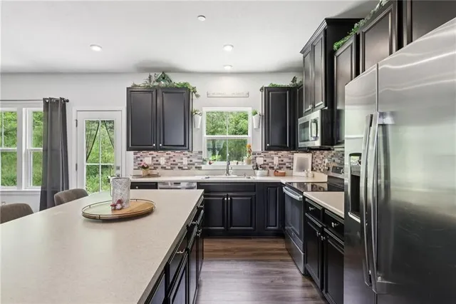 a kitchen with stainless steel appliances a sink stove and refrigerator
