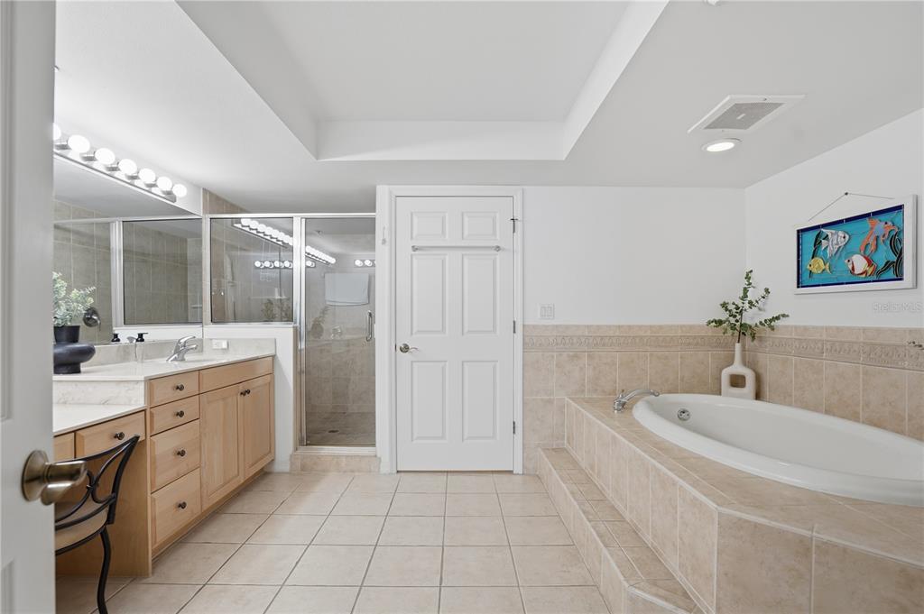 16326 Gulf Boulevard, Unit 307 Redington Beach, FL 33708 - Photo 18 of 43 a spacious bathroom with a double vanity sink a mirror and a bathtub
